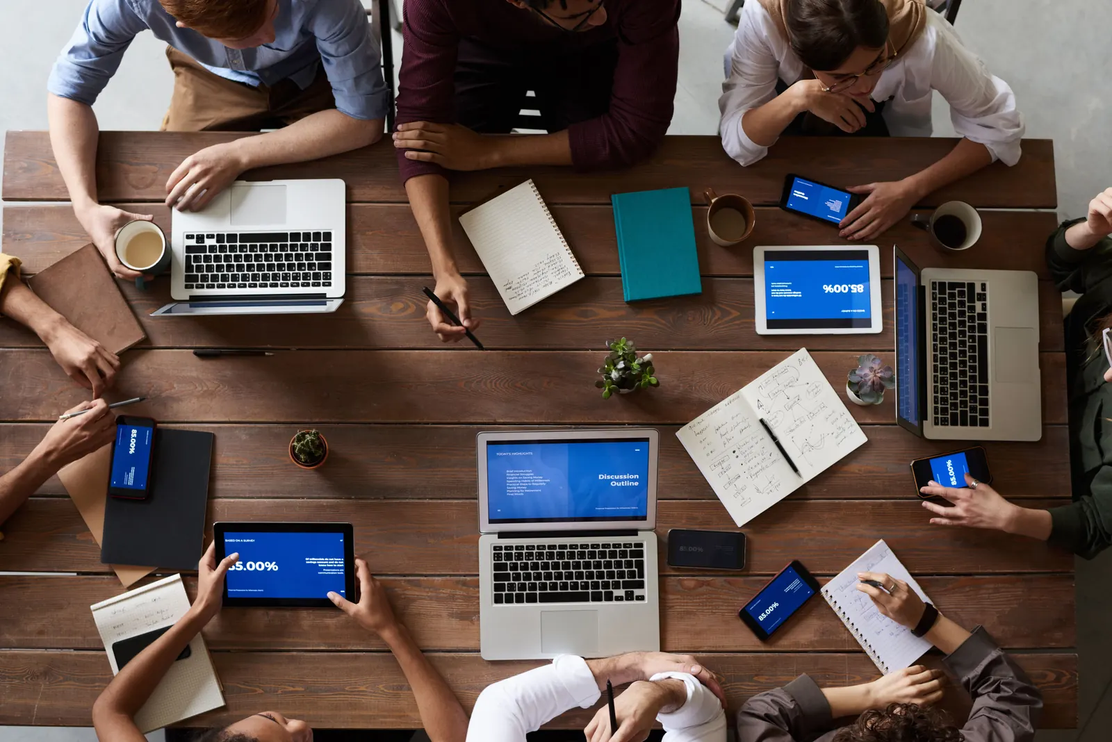 Team di lavoro riunito attorno a un tavolo con computer e documenti