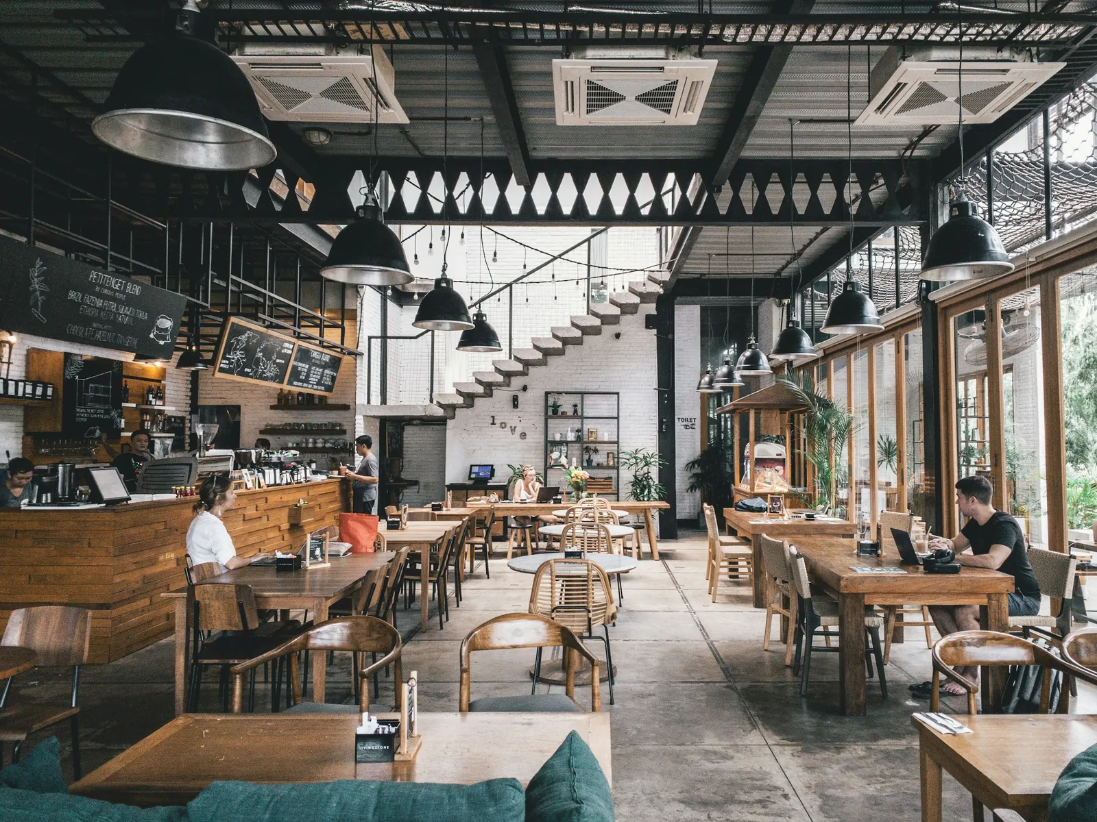 Interno di ristorante con tavoli in legno e piante