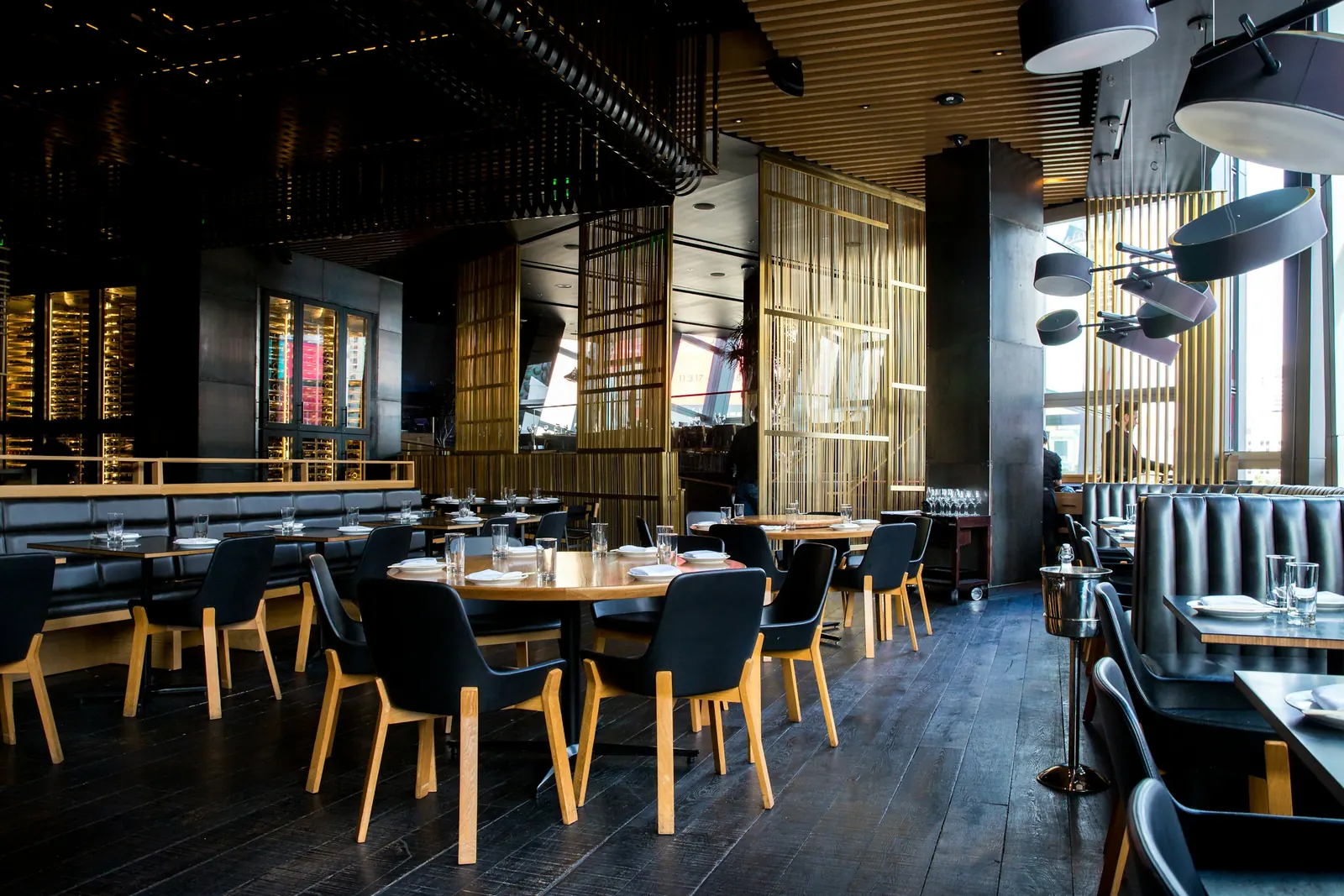 Sala di ristorante vuota con tavoli apparecchiati e luci calde