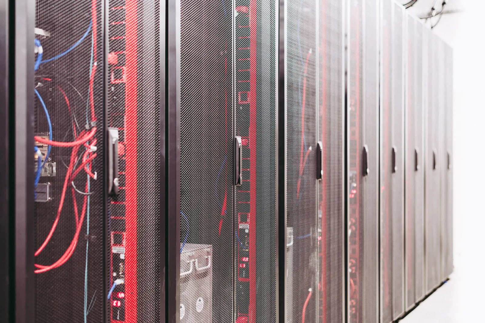 Fila di armadi rack con cavi di rete rossi e blu in una sala server