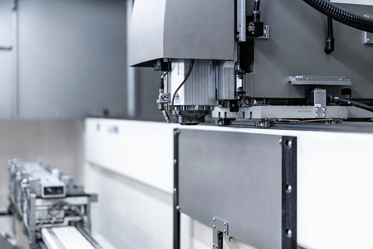 Testa di un centro di lavoro CNC in un reparto produttivo, con il banco di lavoro in primo piano